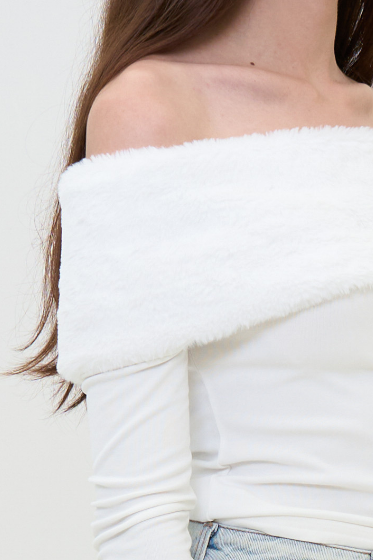 CAPUCINE top - Women's white blouse with fur and wool side close up image. Close-up of a women wearing a white off-shoulder top with a blurred background