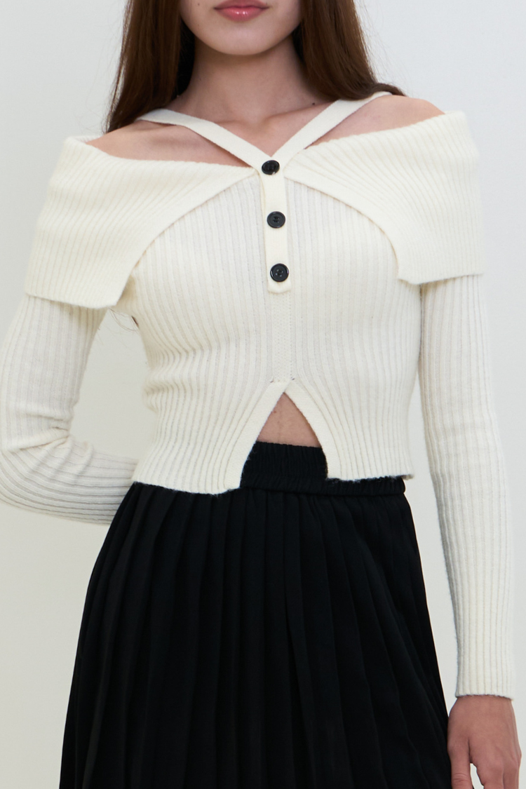 White ribbed sweater blouse with black buttons and black skirt on a white background