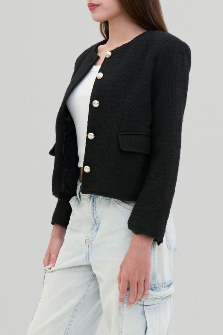 Womens black cardigan jacket with buttons Channel style. Side image. Women’s black jacket with silver buttons. Left side image. Fashion styling. Blazer