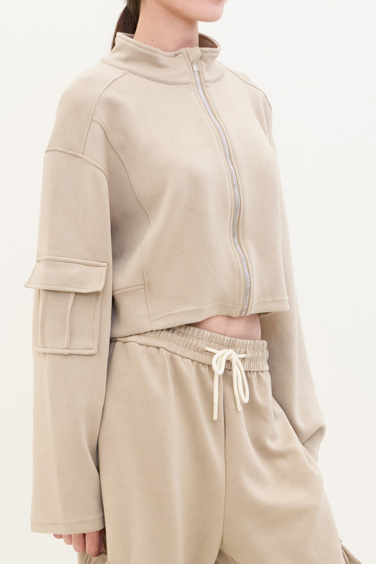 ELOWEN sports-set (Toffee) Track suit zipper sweater and sweatpants beige color. Active wear Front Top Close up. Beige tracksuit worn by a person on a white background