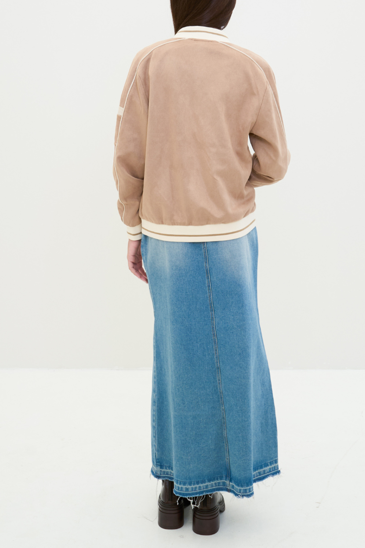 Person wearing a beige jacket and blue denim skirt on a white background. NAILA BASIC jacket in beige color with zipper. Unisex jacket. Back image.