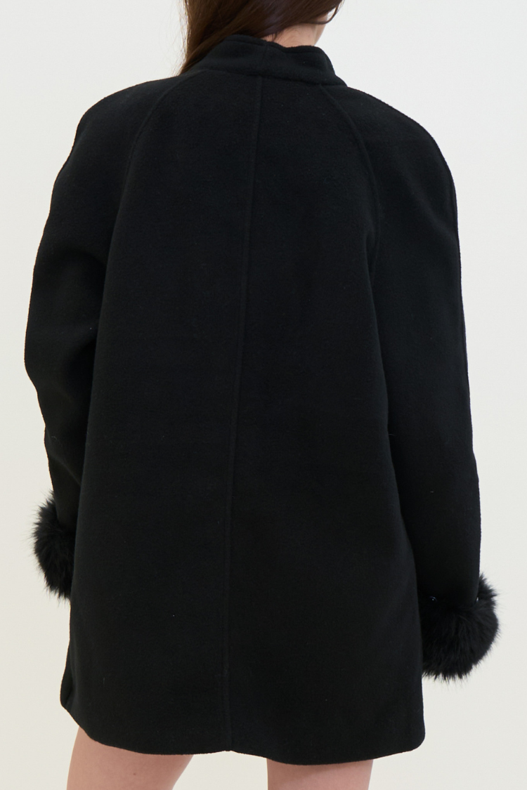 Black coat with fur cuffs on a white background. Black coat with fur cuffs and gold buttons. NOOR coat Women’s back coat. Wool, Combined Cotton, Vegan Fur. Back image.