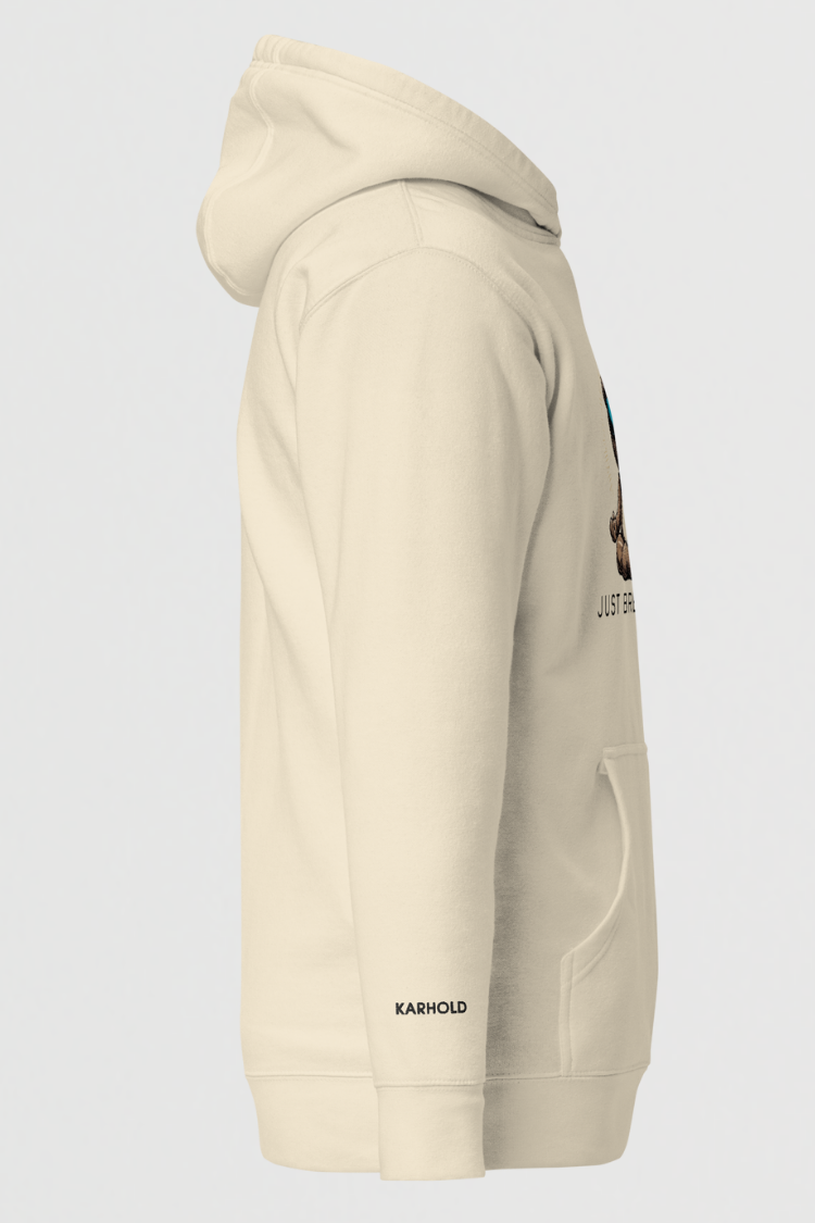 Beige hoodie with brand logo. Unisex hoodie Men’s hoodie Women’s hoodie Beige hoodie with a bear graphic and 'Just Breathe' text. 100% cotton. Side image.