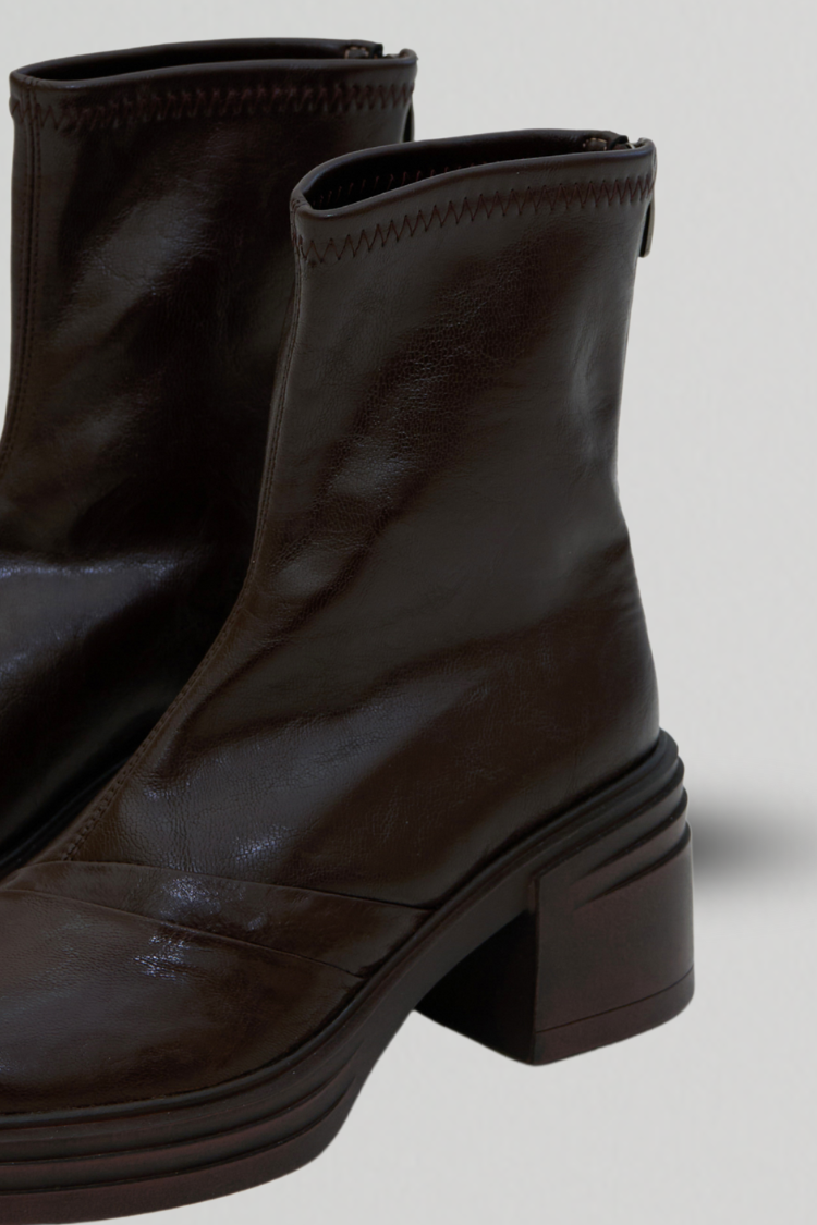 Pair of women's black leather ankle boots. Chelsea boots. Timberland boots. Brown shoes. Brown boots. Riding boots. close up detailed image.