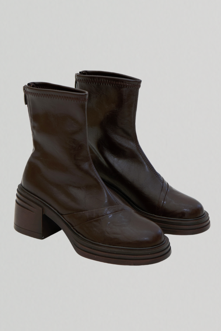 Pair of women's black leather ankle boots. Chelsea boots. Timberland boots. Brown shoes. Brown boots. Riding boots. right image close up.