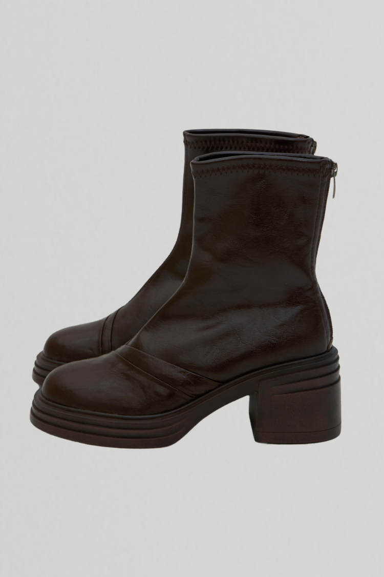 Pair of women's black leather ankle boots. Chelsea boots. Timberland boots. Brown shoes. Brown boots. Riding boots. side image with high heels.