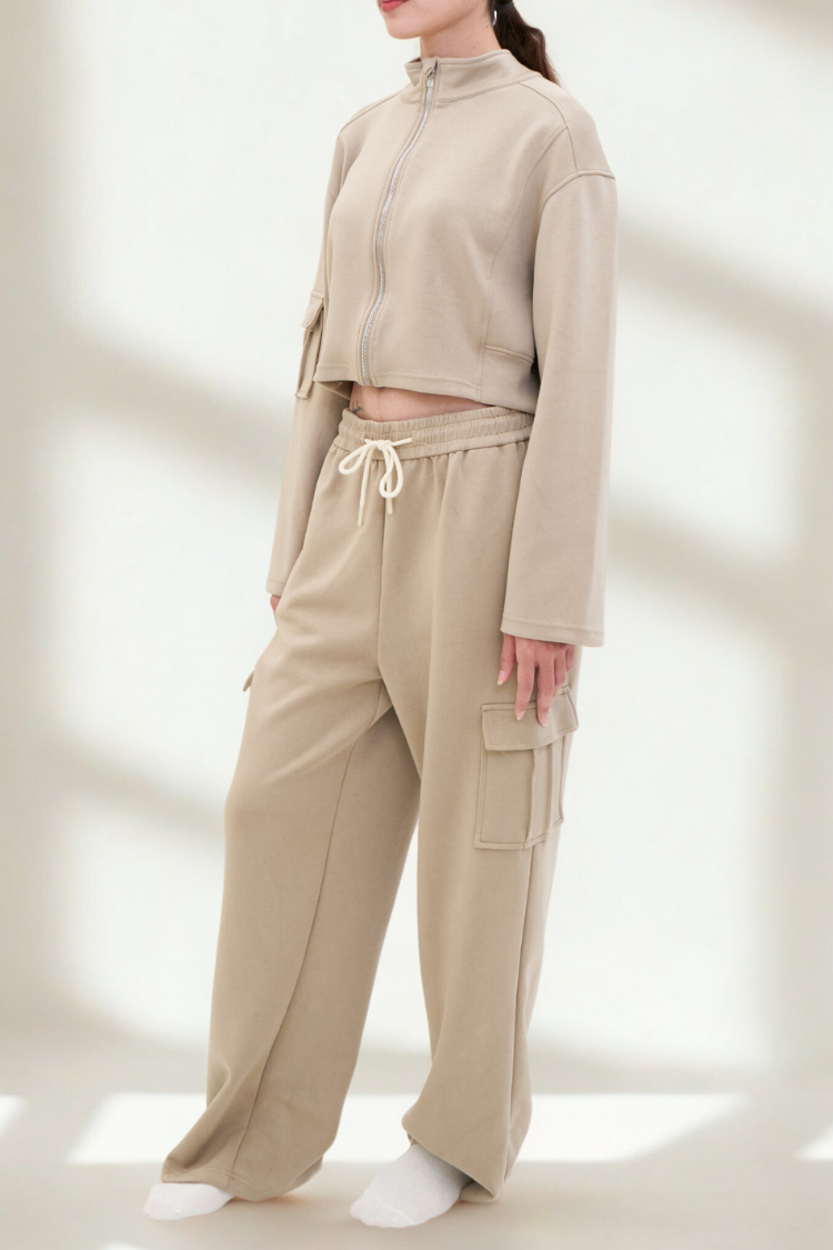 ELOWEN sports-set (Toffee) Track suit zipper sweater and sweatpants beige color. Active wear front display. A woman wearing a beige tracksuit on a light background