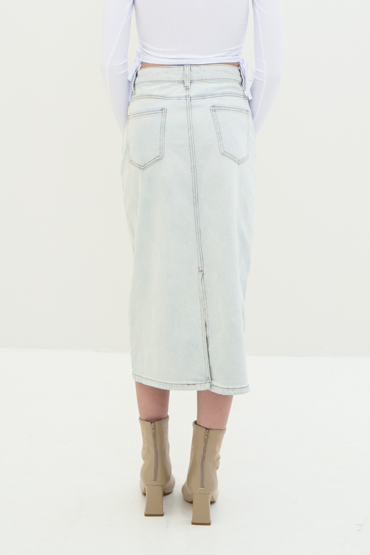Light-colored denim skirt worn by a woman. Back image.